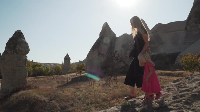 Young mother walking with her daughter in cappcadocia love valley