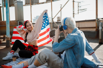 Obraz premium Happy Asian girl sitting with flag on the roof