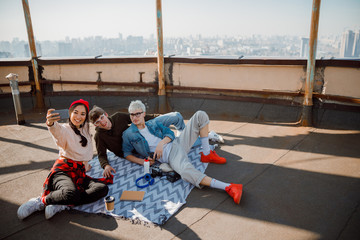 Smiling friends making selfie on the roof