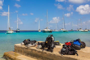 Diving equipment on coast with boats on sea