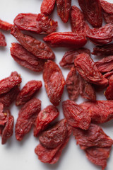 Red dried goji berries on white marble background