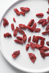 Red dried goji berries on white marble background