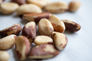 Obraz premium Brazil nuts on white marble background