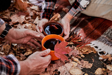 In nature, in the forest, they cooked real hot mulled wine at the stake in the autumn. Pours compote into a cup for himself and his girlfriend to keep warm.