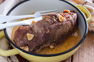 Baked beef fillet with pieces of garlic in a pan, horizontal