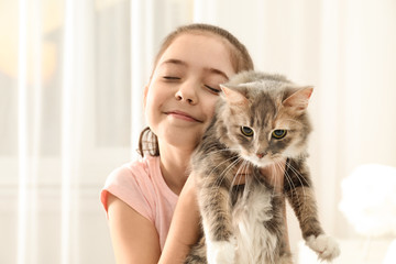 Cute little girl with cat at home. First pet