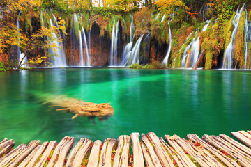 Famous Plitvice lakes and wooden footpath with beautiful autumn colors and magnificent views of the waterfalls at  Plitvice national park