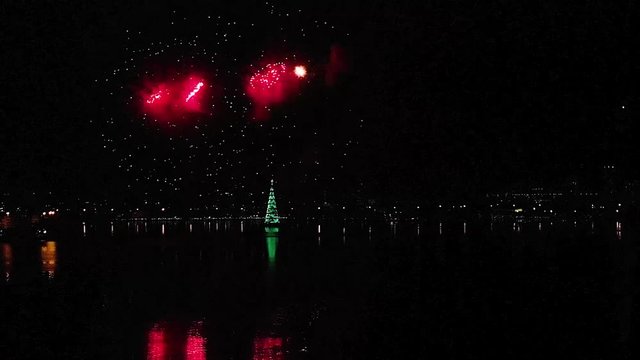 Inauguration of the floating Christmas tree with fireworks reflecting in Rio de Janeiro city lake during the opening