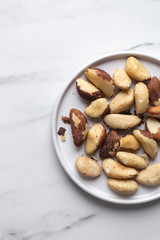 Brazil nuts on white marble background