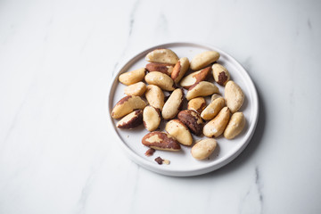 Brazil nuts on white marble background