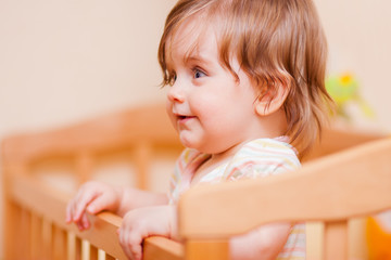 little girl standing in the crib