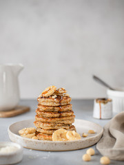 healthy easy breakfast. oatmeal banana pancakes with date syrup. gray background, vertical image