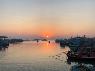 Fototapeta premium Sunrise scenery at sea With fishing boats parked along the coast