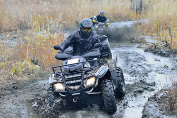 Cool pictures of active ATV driving in mud and water at Autumn weather