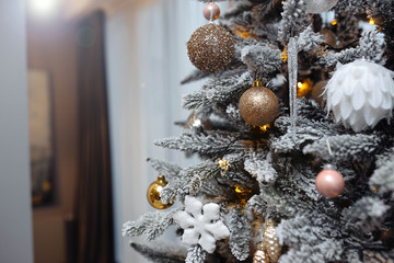 Christmas artificial tree with white snow and decorations toys.