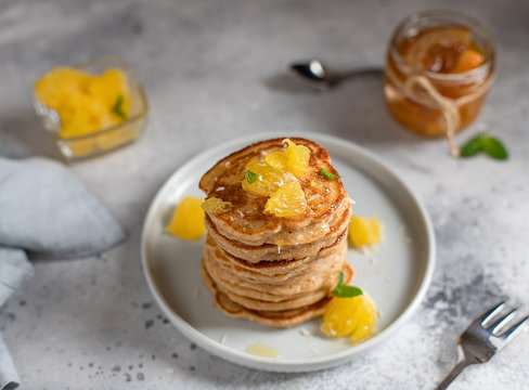 Tasty pancakes served with orange and jam. gray concrete background, horizontal image