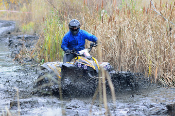 Cool picture of active ATV and UTV driving in mud and water at Autumn
