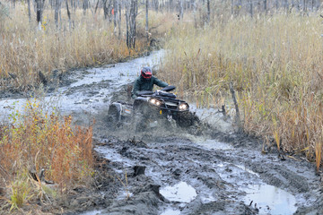 Cool picture of active ATV and UTV driving in mud and water at Autumn