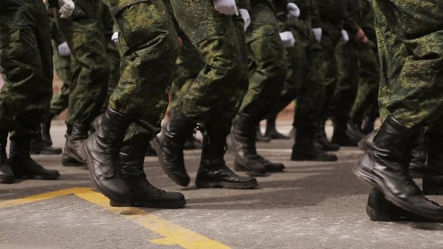 Soldiers marching in a parade through the town, Military Marching of Soldiers in the City in close-up.