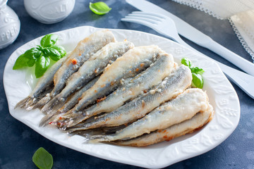 Fried smelt on a white dish, selective focus