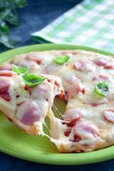 Pizza with tomatoes and sausages cooked in a pan, selective focus
