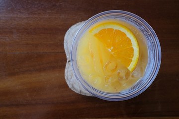 top view of orange juice in glass on wooden background
