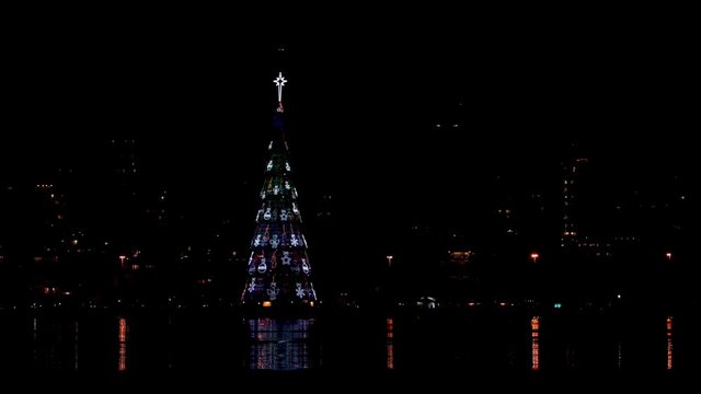 Time lapse of the floating Christmas tree on the city lake of Rio de Janeiro showing all 8 light designs it passes
