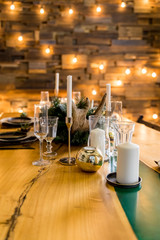 Stylish table setting with burning candles and Christmas decorations.Beautiful table setting with Christmas decorations in living room. festive decoration on table, romantic holiday evening