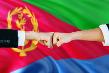Eritrea agreement concept. Man and woman fist bumping on national flag to show cooperation. Peace...