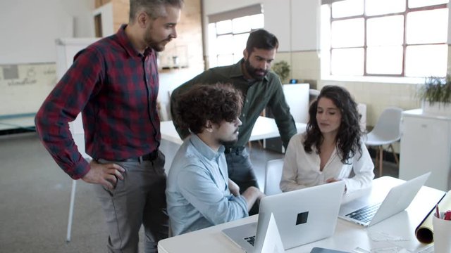Group of focused young people sharing ideas with each other. Group of confident young people working together in cozy office. Startup concept