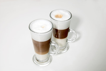 two clear glasses of latte macchiato coffee