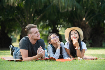 Fototapeta premium Happy family day vacation spend time together, lying on green grass in the park.
