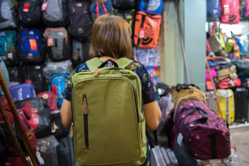 Traveller woman choose and buy backpack at store.