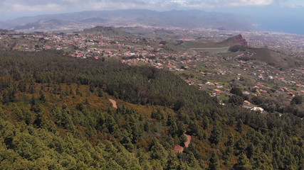 Beautiful landscape of the valley at the foot of the mountain. Coniferous forest, small town and ocean in the distance