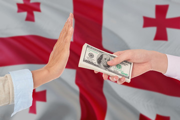 Georgia bribery refusing. Closeup of female hands extending a pile of dollar bills to the male...