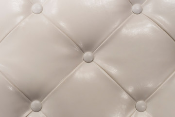 Part of light leather sofa. Textured background. View from above. Rhombic pattern.