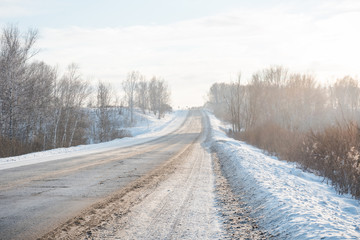 The road through the snowy forest. Asphalt road in the winter. The path through the winter forest. Winter has come. Winter landscape