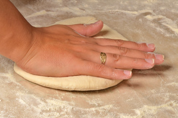 Woman preparing the dough for pizza. Close-up of woman hands.
