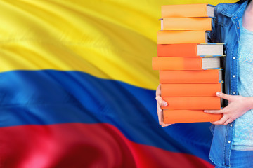 Colombia national education concept. Close up of female student holding colorful books with country...