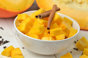 Bowl of chopped pumpkin, cloves and cinnamon prepared for fruit stew compote.