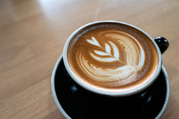 Close up of latte art coffee on wooden table