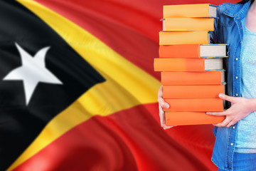 East Timor national education concept. Close up of female student holding colorful books with...