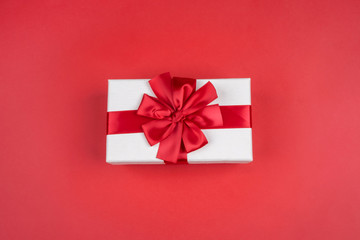 Beautiful gift box with red bow on red background. The concept of the holiday, Christmas, sales
