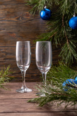 Glasses for champagne and a bottle on the background of New Year's decor. Copy space. Close-up.