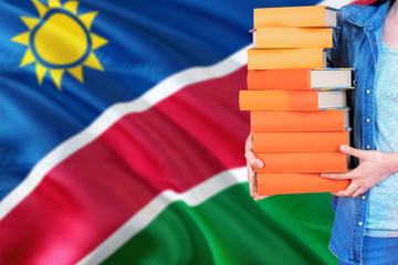 Namibia national education concept. Close up of female student holding colorful books with country...