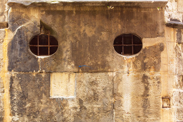 Part of a gothic building with bars on the windows