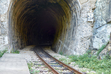 Railway track passing through an old tight tunnel
