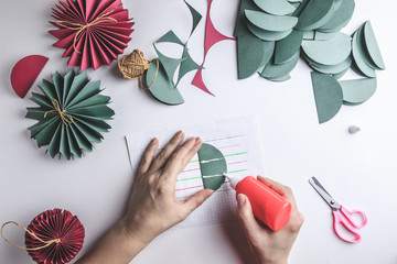 Christmas handmade background. Female hands making paper decoration balls. Step by step. DIY...