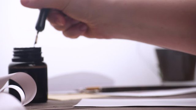 Close up view of hand writing with stylus and ink on the postcard. Fine penmanship. Words are not visible for viewer. 4k. Shallow depth of field.