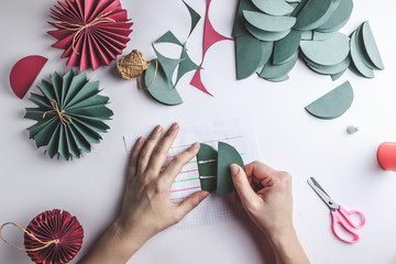 Christmas handmade background. Female hands making paper decoration balls. Step by step. DIY...